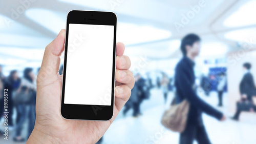 Hand holding mobile phone with blurred image of people use for b