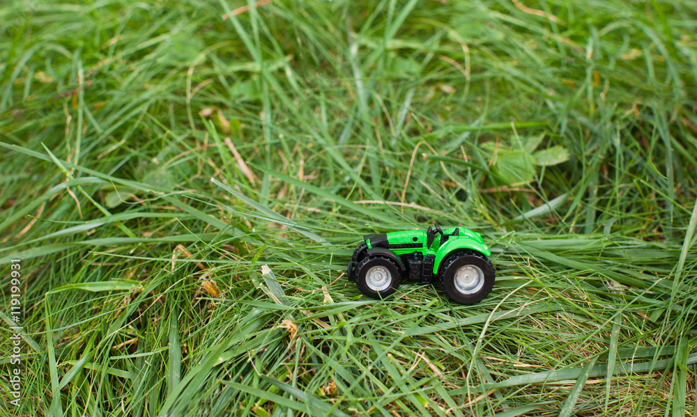 Fototapeta premium children's toy tractor on a green field