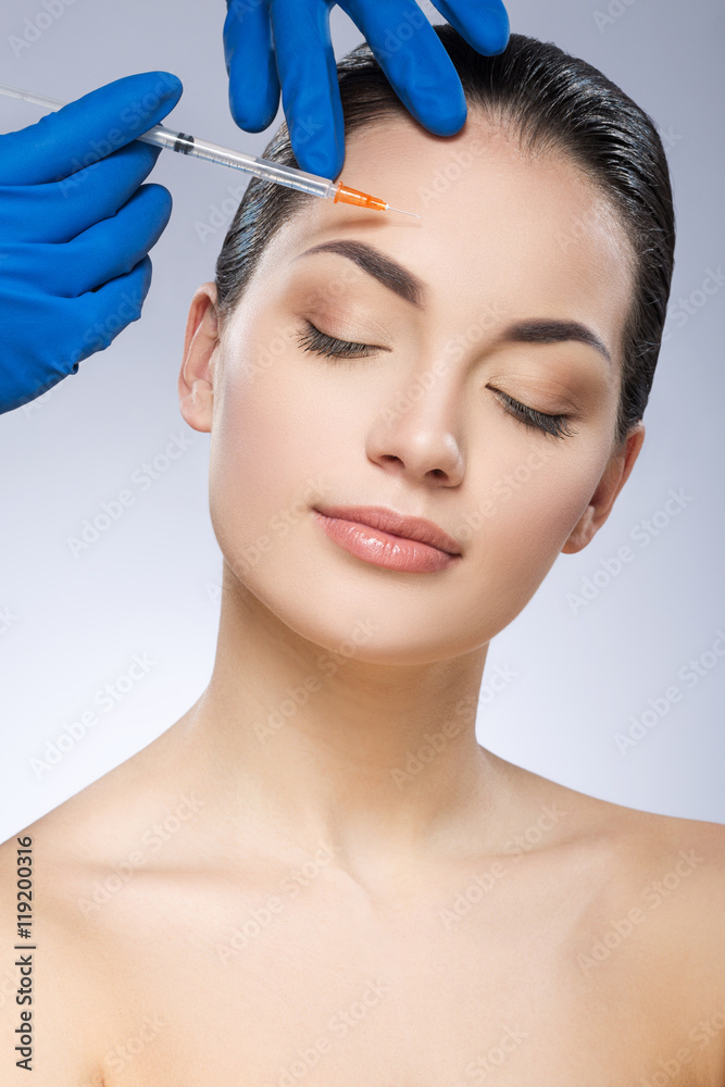 Young girl receiving cosmetic injection with syringe