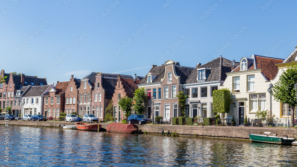 Village landscape as seen from the river Vecht of  the old dutch village Maarssen with characteristic stepped gable houses. 