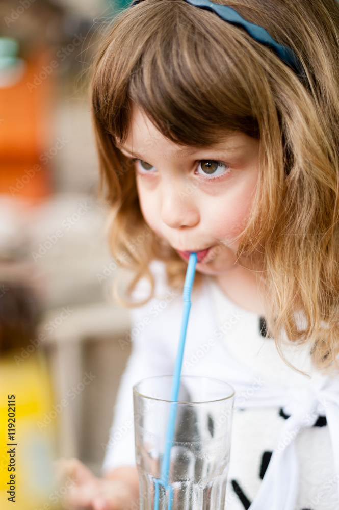 Little girl drinking juice through a straw
Little girl drinking juice through a straw