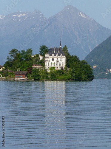 View across Brienzersee Lake, Switzerland towards Iseltwald castle and Niesen mountain beyond 