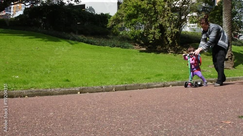 Wallpaper Mural Mother teach her child (girl age 2) to ride a scooter. Family, motherhood and parenthood  lifestyle concept. copy space Torontodigital.ca
