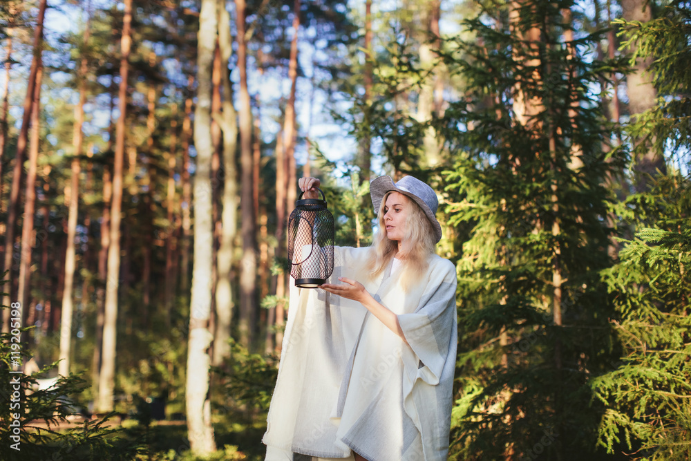 woman tourist with a lantern in a forest at sunset woman tourist with a lantern in a forest at sunset