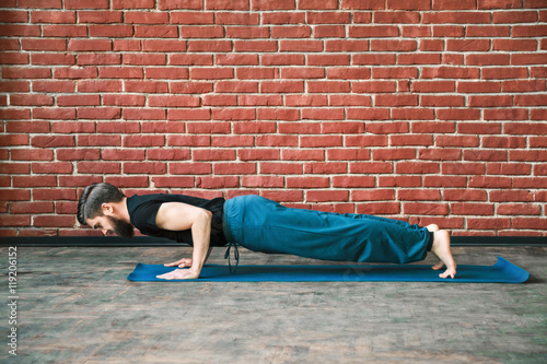 Handsome man doing yoga positions