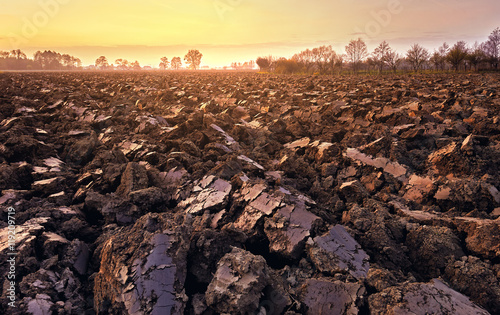 Fotografie plowed soil. spring field. sunset over ploughed field. Countrysi