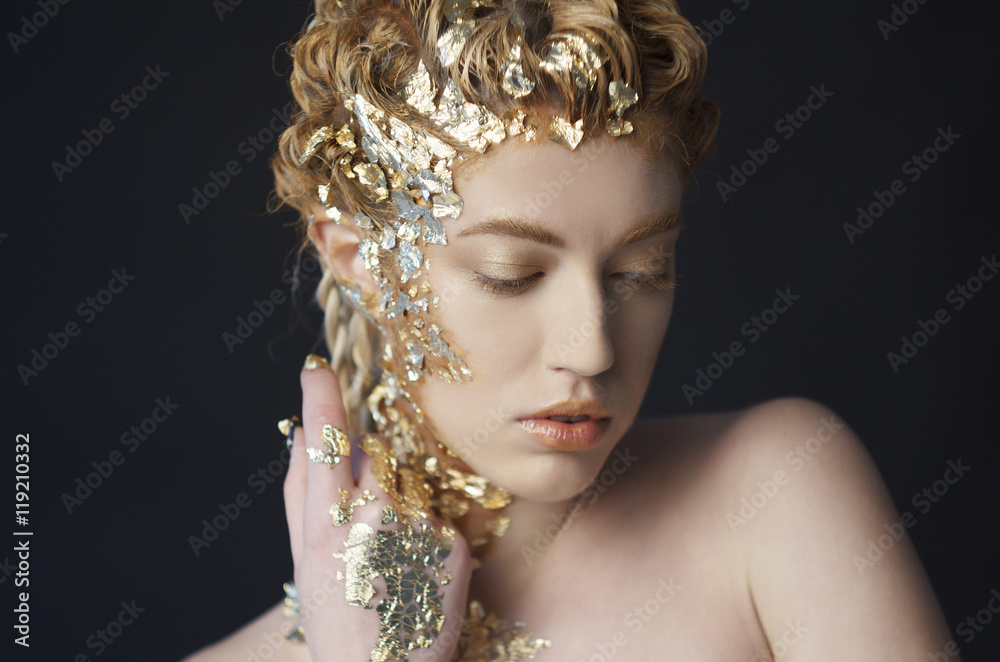 Portrait of beautiful model with shiny foil on face and hair