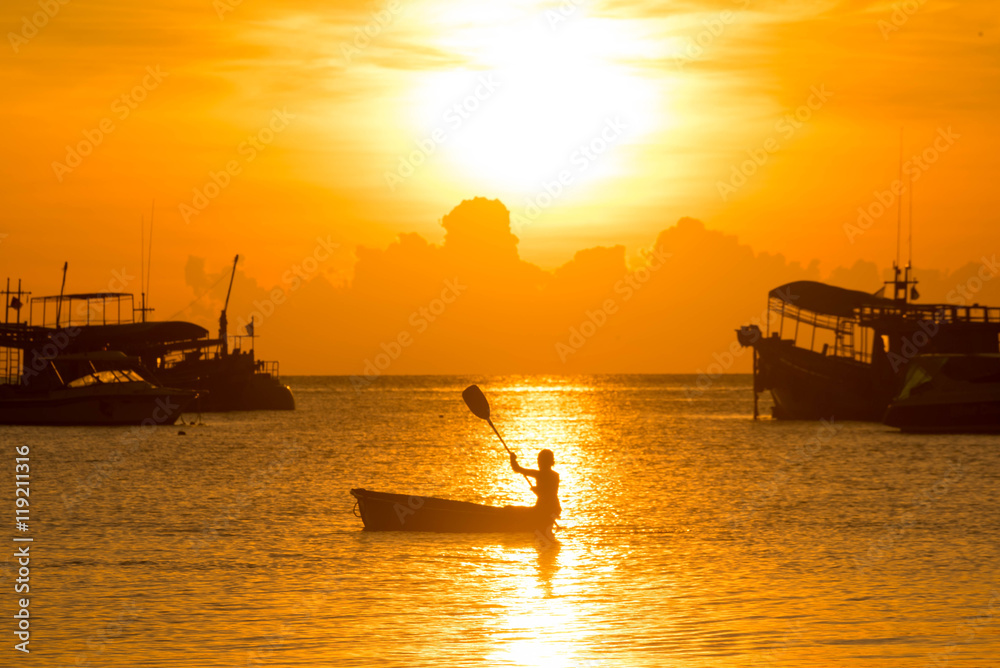 Silhouette of a boy rowing in the canoe Silhouette of a boy rowing in the canoe