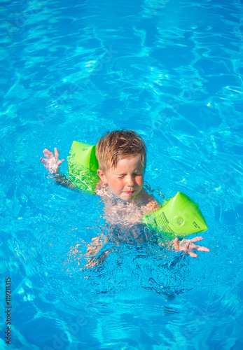 little boy in life ring having fun in the pool