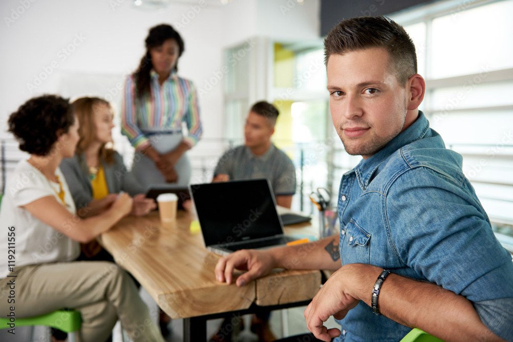 Image of a succesful casual business man using laptop during meeting Image of a succesful casual business man using laptop during meeting