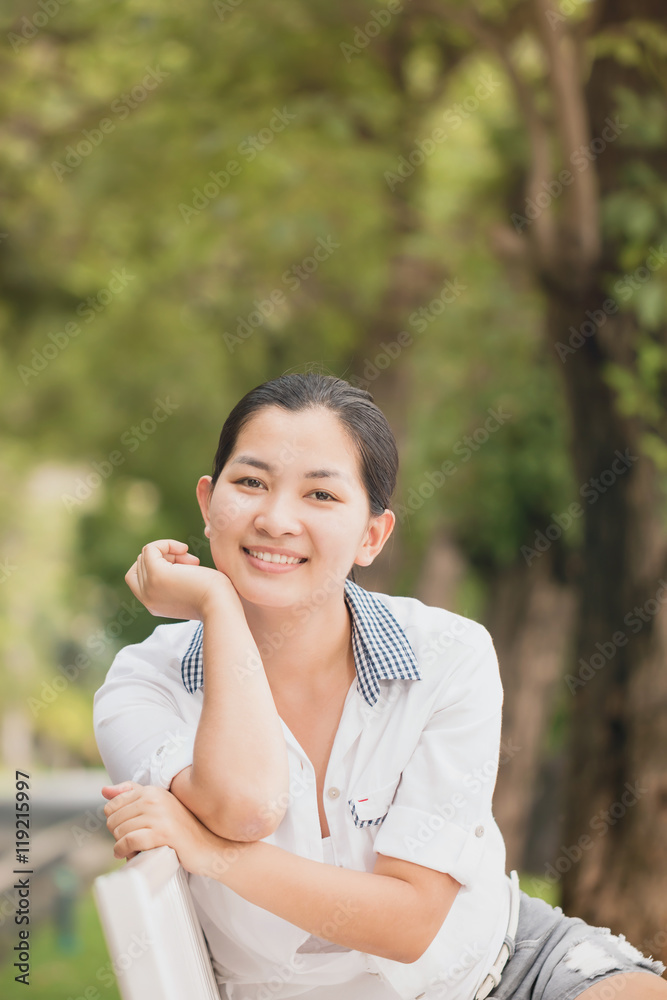 Young asian woman relaxing outdoors looking happy and smiling Young asian woman relaxing outdoors looking happy and smiling