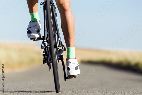 Close-up of the foot of a young man cycling.