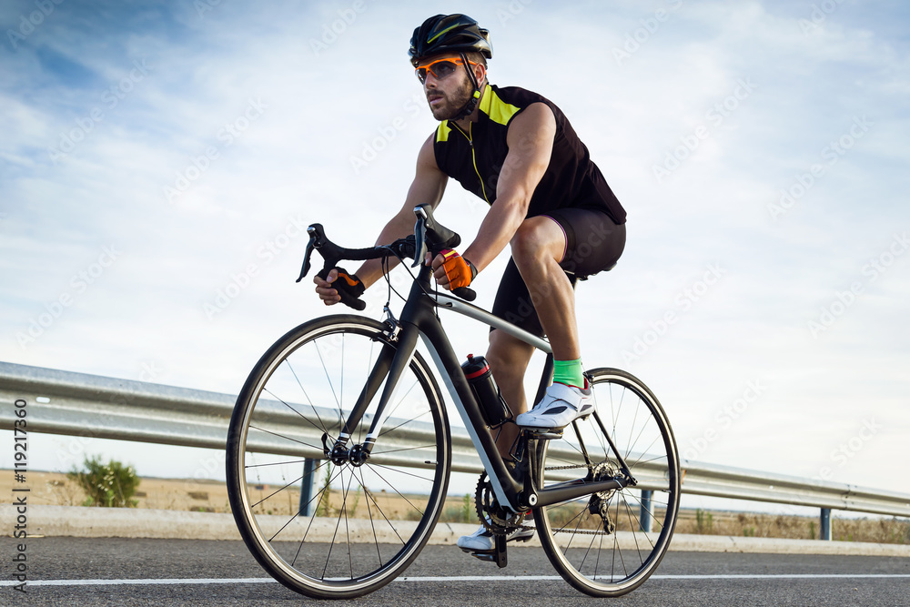 Fototapeta premium Handsome young man cycling on the road.