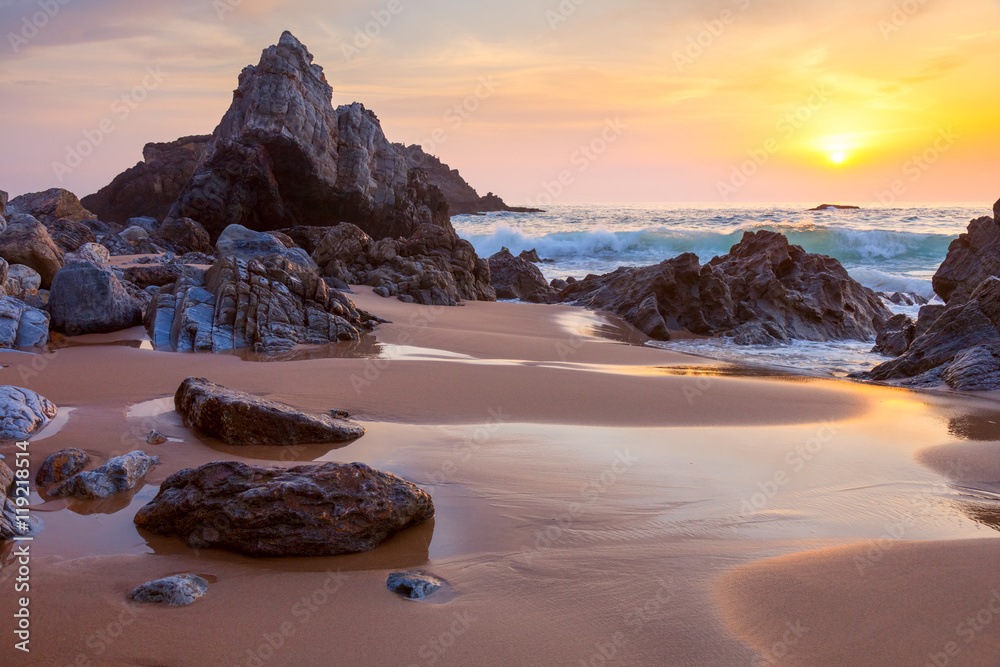 landscape of big rocks the ocean beach at sundown