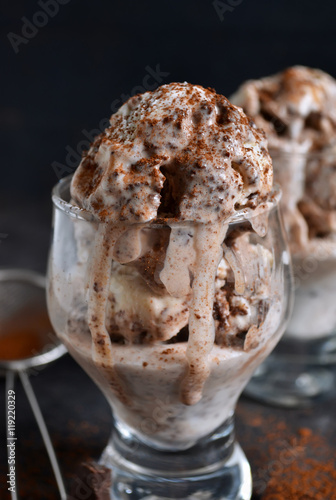 chocolate ice cream with pieces of chocolate and coffee on a bla
