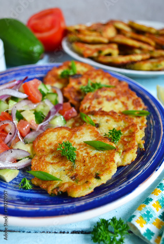 potato pancakes with vegetable salad on a blue background