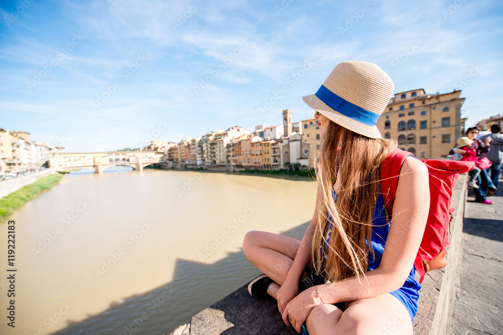 Young female traveler enjoying the view on the famous Ponte Vecchio bridge in Florence city