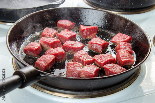 Obraz na płótnie Searing beef bottom round roast cubes in cast iron skillet , meat just added to hot oil , the upper sides are still red w salonie