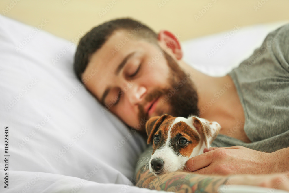 Handsome man with cute dog sleeping in bed Handsome man with cute dog sleeping in bed