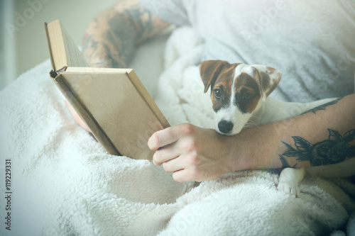 Man with cute dog reading book