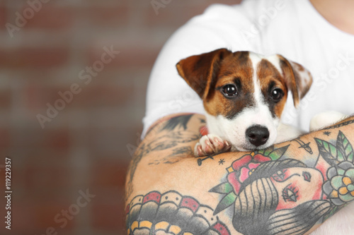 Man holding cute dog on bri...