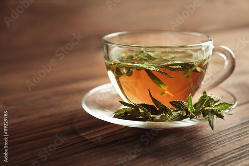 Cup of sage tea on wooden background