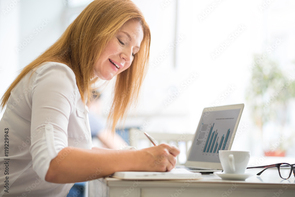 Positive content woman sitting at the table Positive content woman sitting at the table