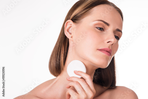 Cute young woman with cotton pad