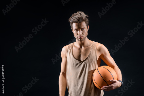 Confident young man playing basketball