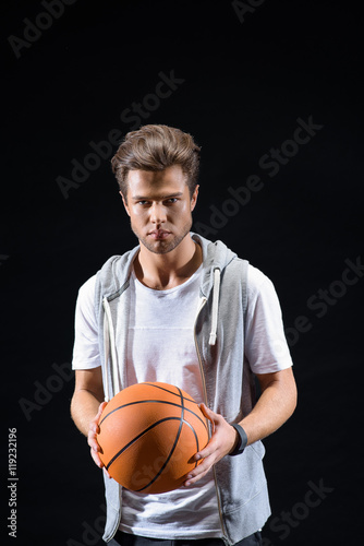 Cheerful young man playing basketball