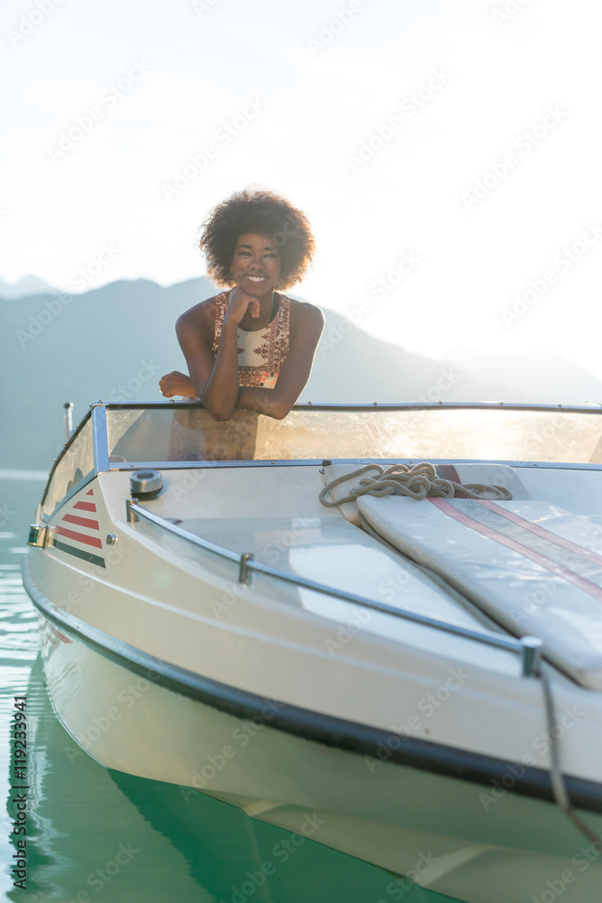Summer vacation - young afro  woman on a motor boat or speedboat