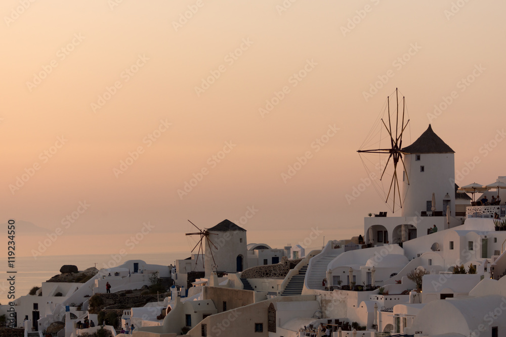 Fototapeta premium Niesamowity zachód słońca nad białymi wiatrakami w miejscowości Oia i panorama na wyspę Santorini, Thira, Cyklady, Grecja
