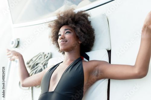 afro woman relaxing on a speedboat. photo