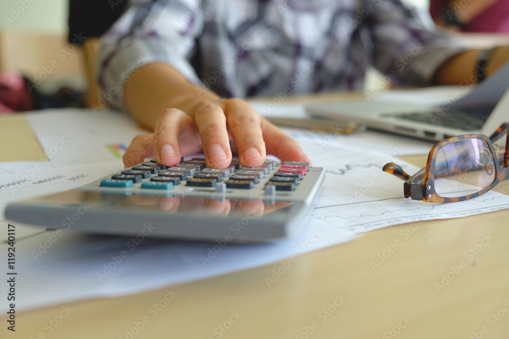 Fototapeta premium Asian Business woman using a calculator to calculate the numbers vintage tone