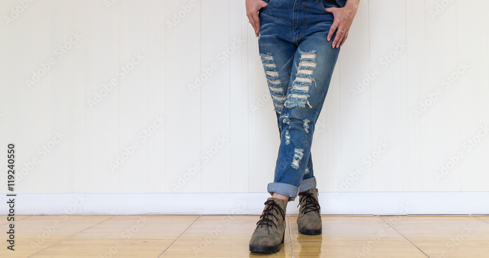 jeans woman wearing jeans and wearing brown leather shoes. Standing against a white wall jeans woman wearing jeans and wearing brown leather shoes. Standing against a white wall