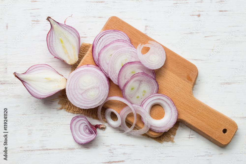 Red onion slices on rustic wooden table background Red onion slices on rustic wooden table background