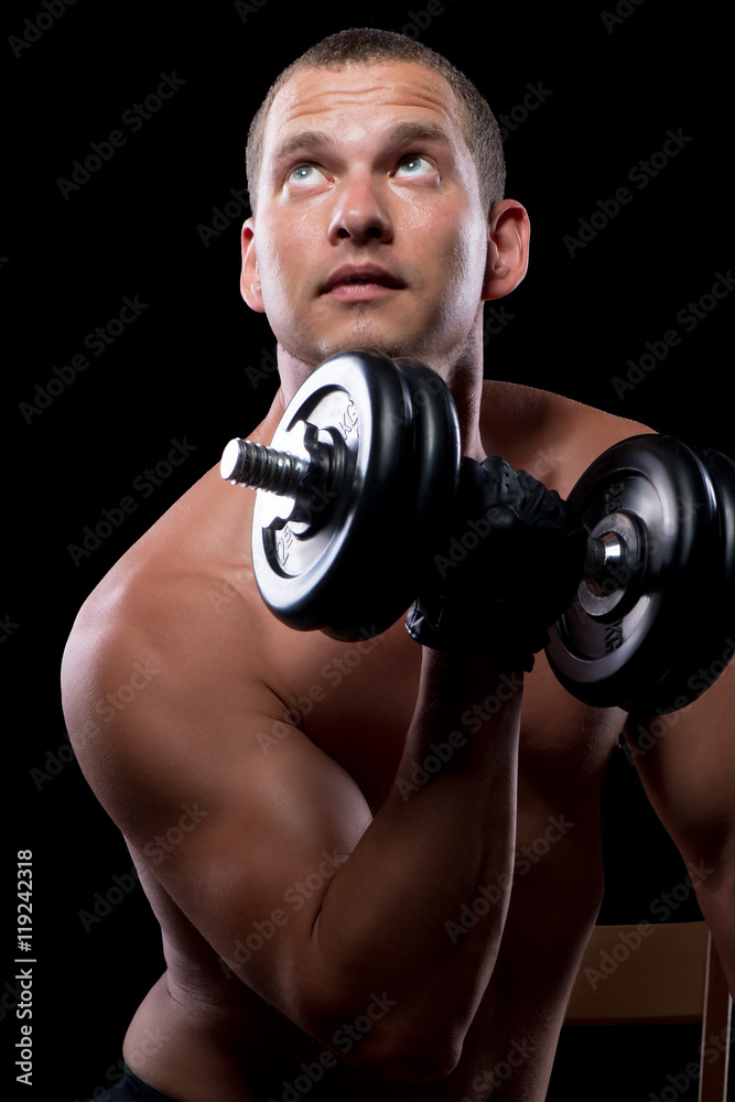 pensive bodybuilder while training with dumbbells