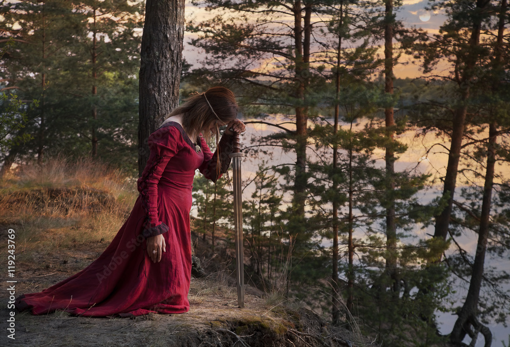 Young woman with a sword praying Young woman with a sword praying