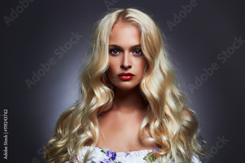 luxury beautiful young woman with healthy curl blond hair. long wavy hair girl with make-up