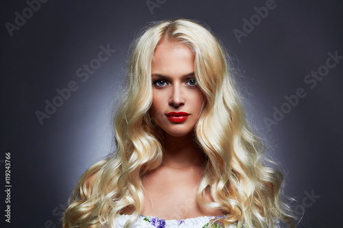 luxury beautiful young woman with healthy curl blond hair. long wavy hair girl with make-up