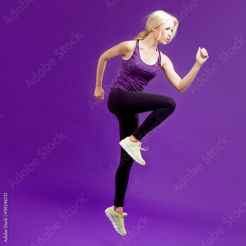 Beautiful young girl in a pose runner. Studio background, purple © Ulia Koltyrina