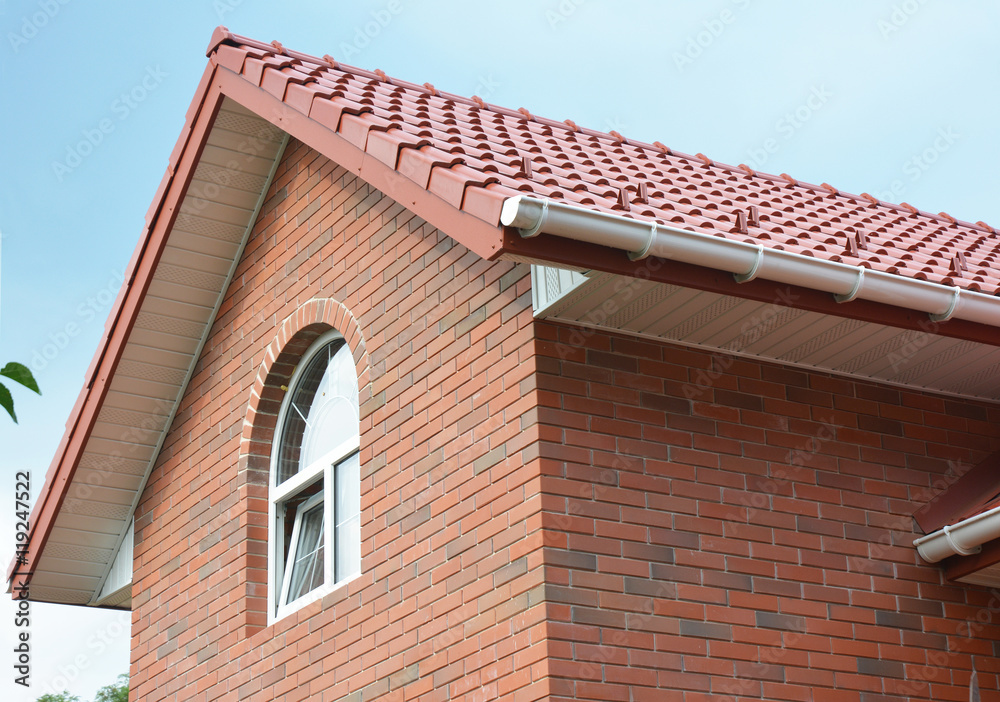 Close up on attic brick house roof construction with ceramic tiles