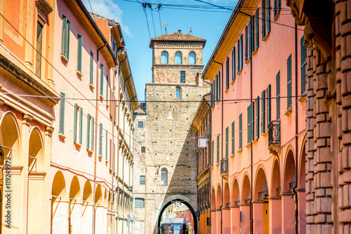 Street view with city gate and galleries in Bologna in Italy