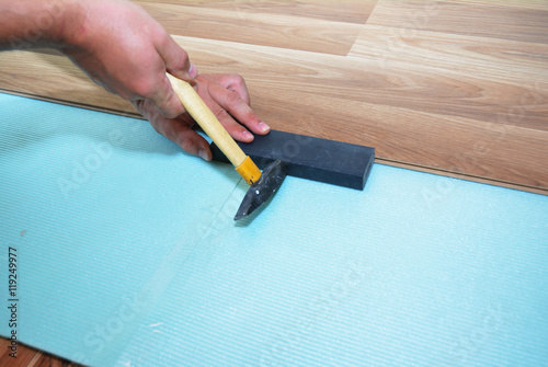 Man Installing New Laminate Wood Flooring. Worker Installing wooden laminate flooring. Step by Step.