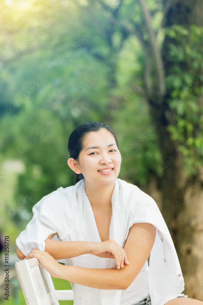 Young asian woman relaxing outdoors looking happy and smiling Young asian woman relaxing outdoors looking happy and smiling