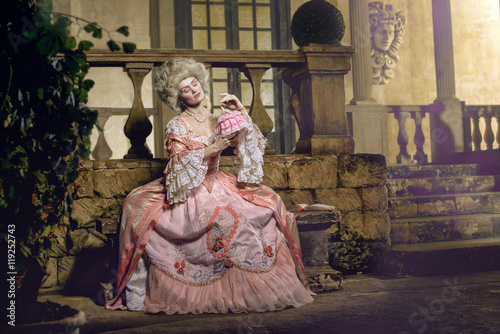 Victorian lady. Young woman in eighteenth century image posing in vintage interior