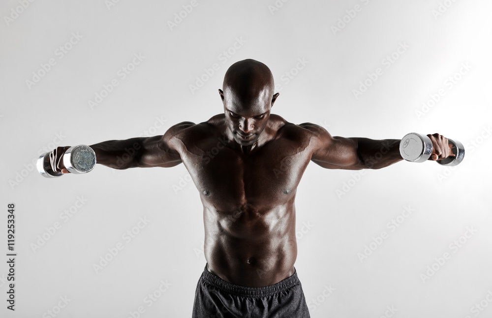 African man doing arms exercise with dumbbells