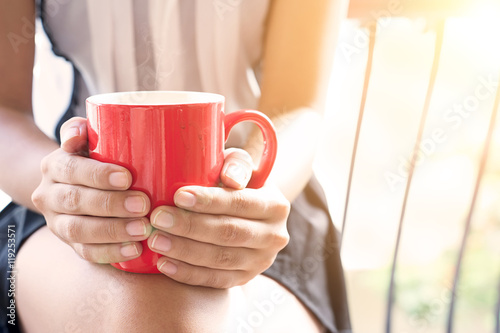Young woman hands holding coffee mug in the morning day , Vintag