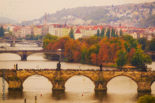 Center of Prague city at autumn with red roofs and Charles Bridge over river Vltava, european travel landscape background in vintage style