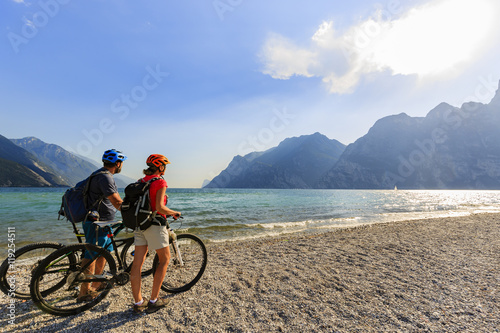 Mountain biking. Couple with bikes on Lake Garda, Riva del Garda, Italy.